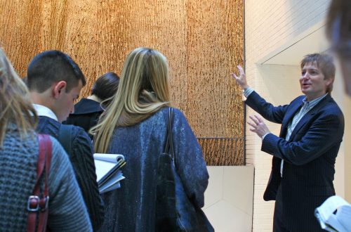 Professor showing off newly installed Bark House brand poplar bark wall panels
