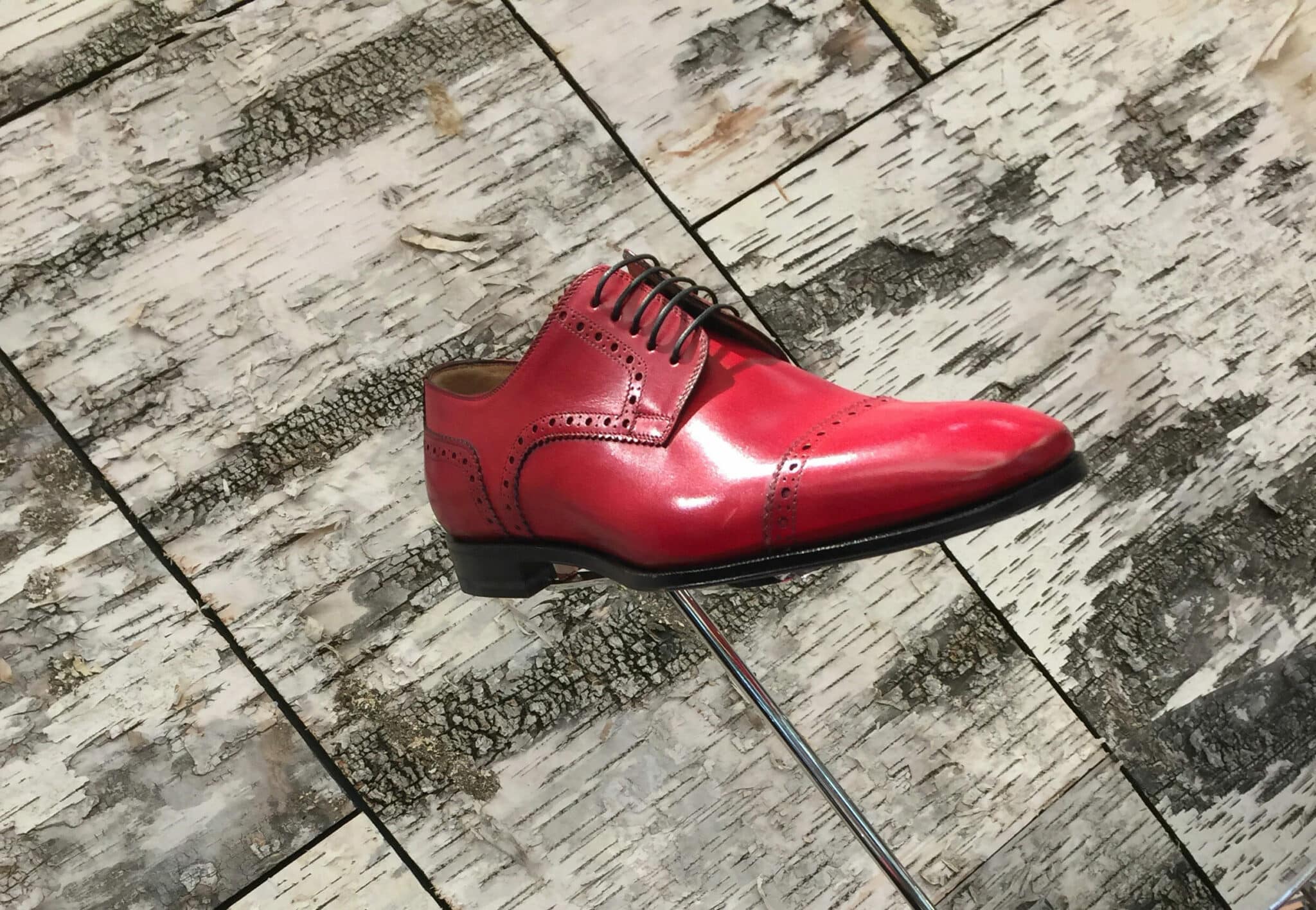 Birch wall panels display Christian Louboutin men's shoe