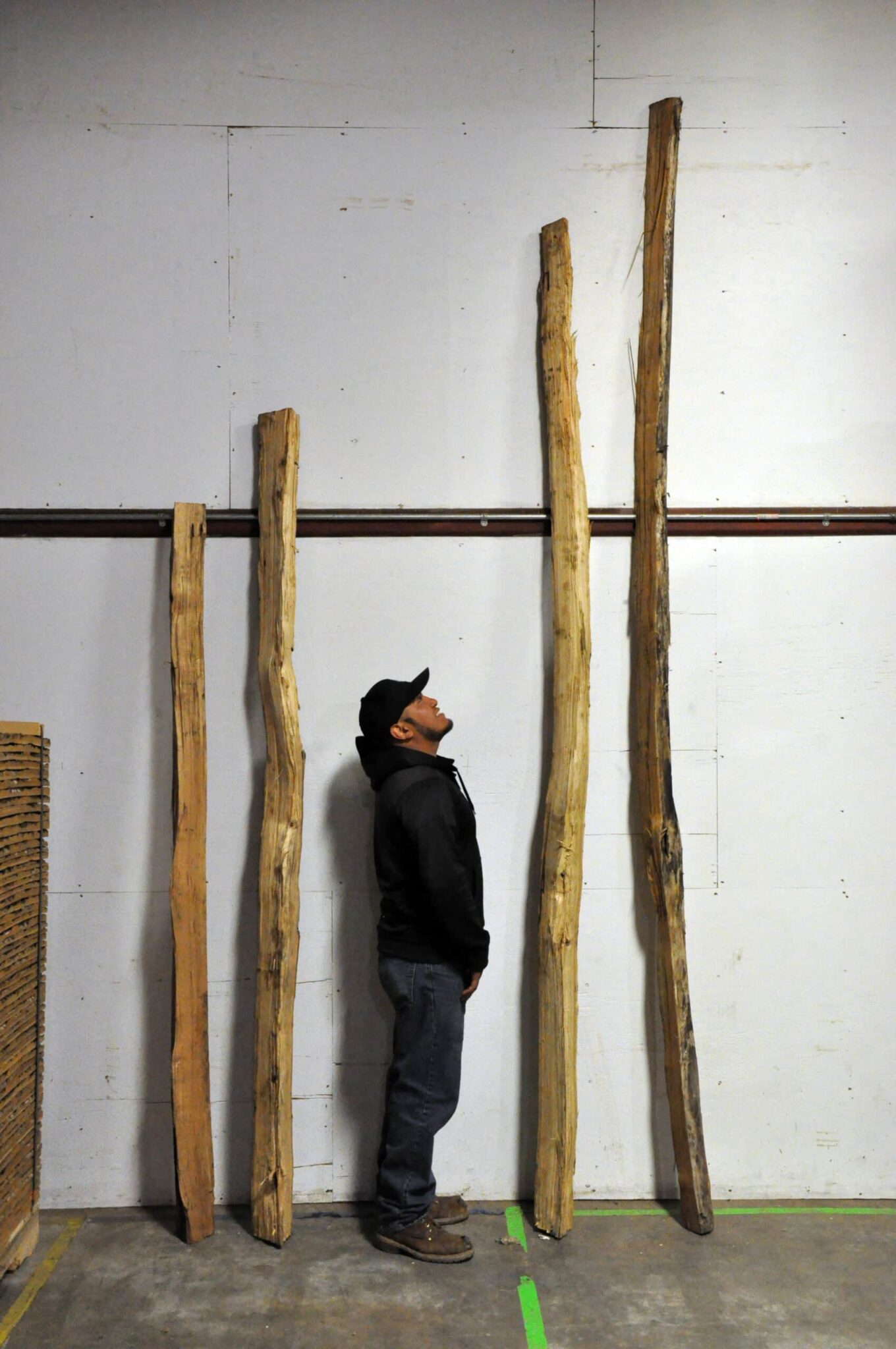 Tony, a Bark House Team Expert, helps illustrate the lengths of traditional Black Locust Split Rails and Posts